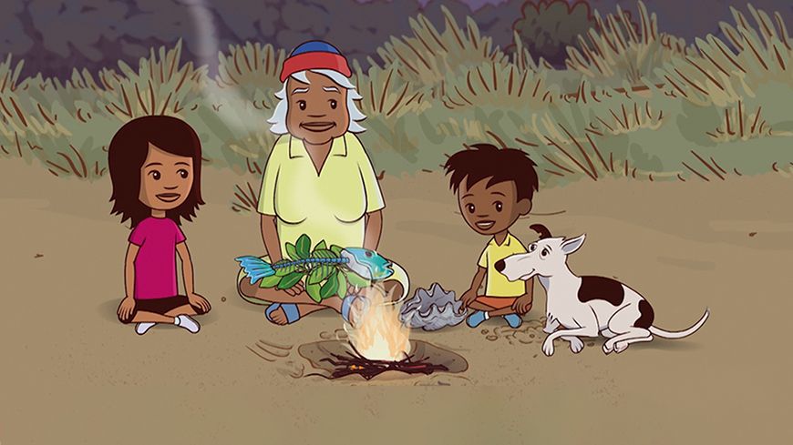 Little J and Big Cuz Two children, a girl and a boy, sit beside an elderly man in a yellow shirt, all smiling at each other. In front of them, a campfire crackles with flames, while a dog lays nearby. The girl holds a large fish and some leaves, suggesting they are preparing a meal outdoors. Lush greenery surrounds them in a twilight setting.